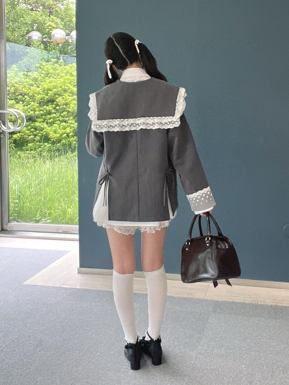 ブラウン系のハンドバッグ、ホワイト系のその他パンツ、ブラック系のパンプスを着用したレディースの秋コーディネートの3枚目の写真