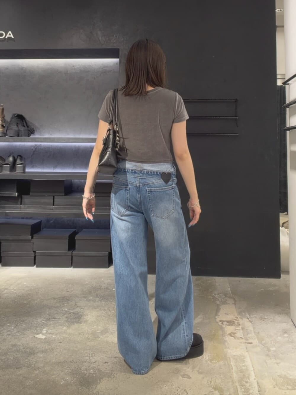 グレー系のTシャツ/カットソー、ブルー系のデニムパンツ、ブラック系のスリッポンを着用したレディースの夏コーディネートの4枚目の写真