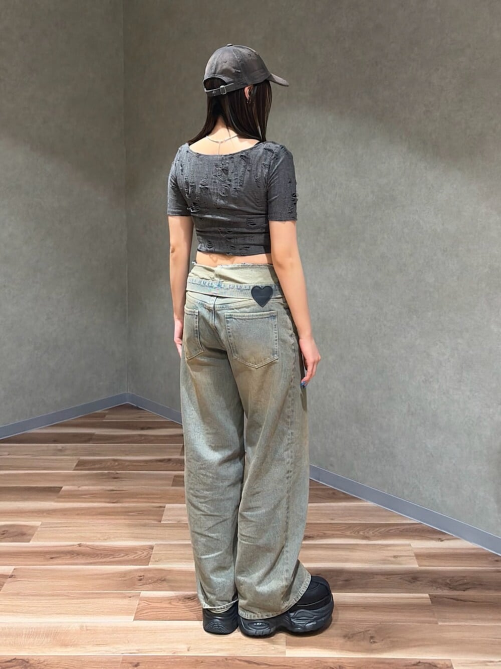 グレー系のTシャツ/カットソー、ブラック系のスニーカー、ブラウン系のデニムパンツを着用したレディースの夏コーディネートの4枚目の写真
