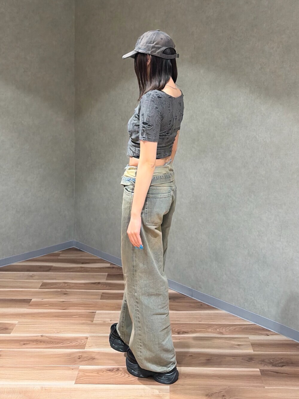 グレー系のTシャツ/カットソー、ブラック系のスニーカー、ブラウン系のデニムパンツを着用したレディースの夏コーディネートの3枚目の写真
