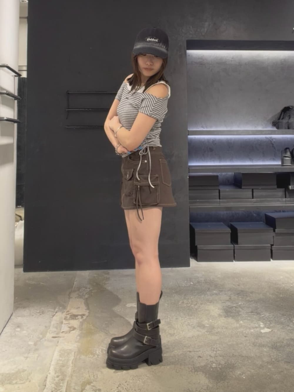 ブラック系のブーツ、グレー系のTシャツ/カットソー、ブラウン系のスカートを着用したレディースの夏コーディネートの3枚目の写真