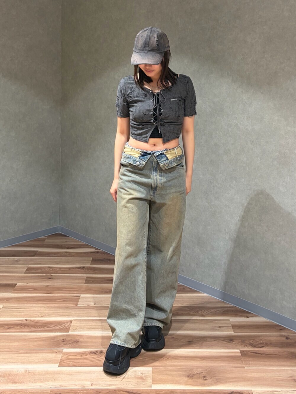 グレー系のTシャツ/カットソー、ブラック系のスニーカー、ブラウン系のデニムパンツを着用したレディースの夏コーディネートの2枚目の写真