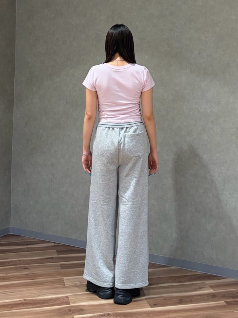 ブラック系のスニーカー、ピンク系のTシャツ/カットソー、グレー系のその他パンツを着用したレディースの夏コーディネートの4枚目の写真