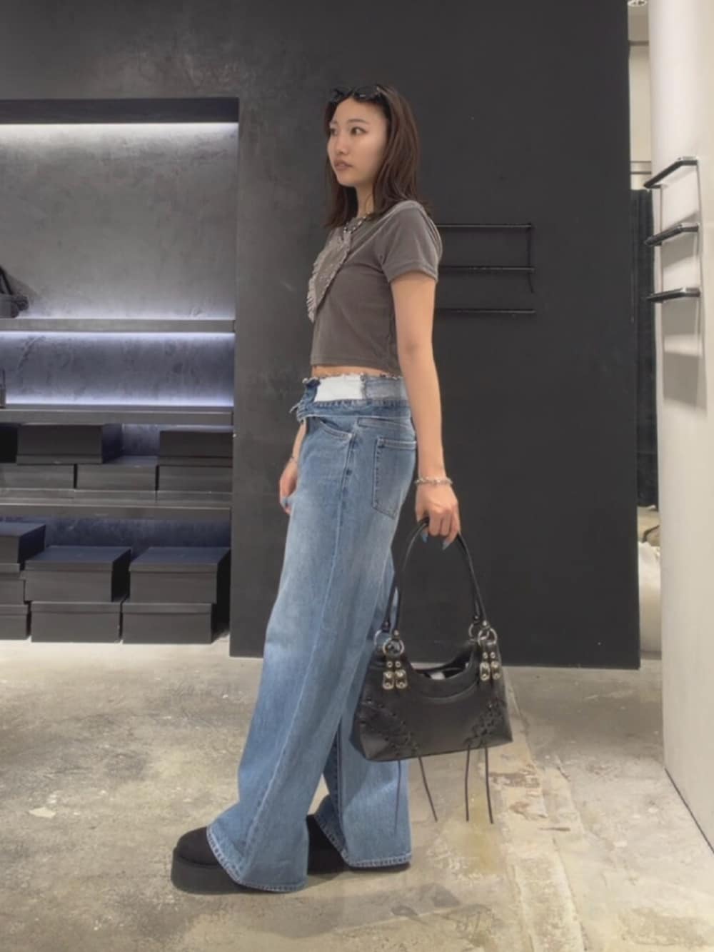 グレー系のTシャツ/カットソー、ブルー系のデニムパンツ、ブラック系のスリッポンを着用したレディースの夏コーディネートの2枚目の写真