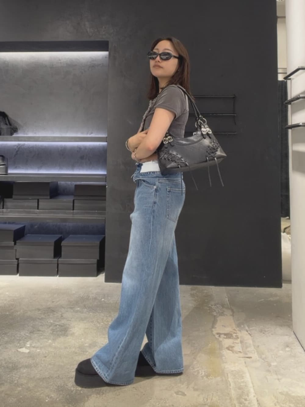 グレー系のTシャツ/カットソー、ブルー系のデニムパンツ、ブラック系のスリッポンを着用したレディースの夏コーディネートの3枚目の写真