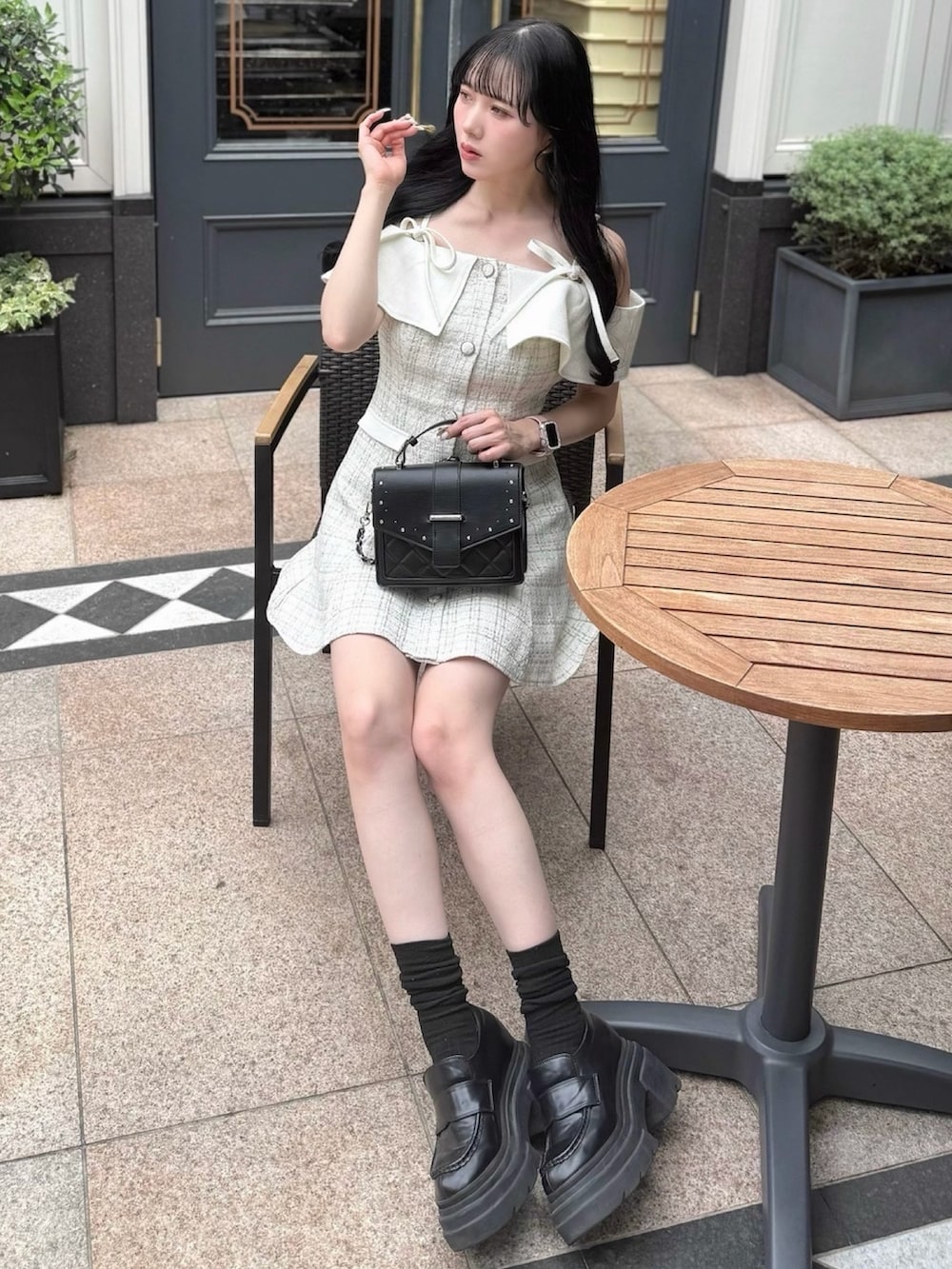 ホワイト系のワンピース、ブラック系のローファー、ブラック系のショルダーバッグを着用したレディースの夏コーディネートの3枚目の写真