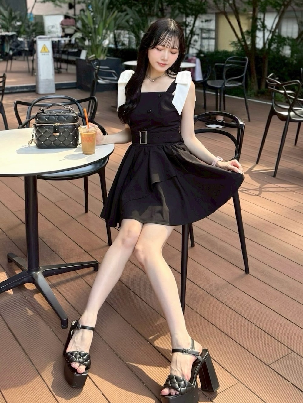 ブラック系のワンピース、ブラック系のショルダーバッグを着用したレディースの夏コーディネートの3枚目の写真