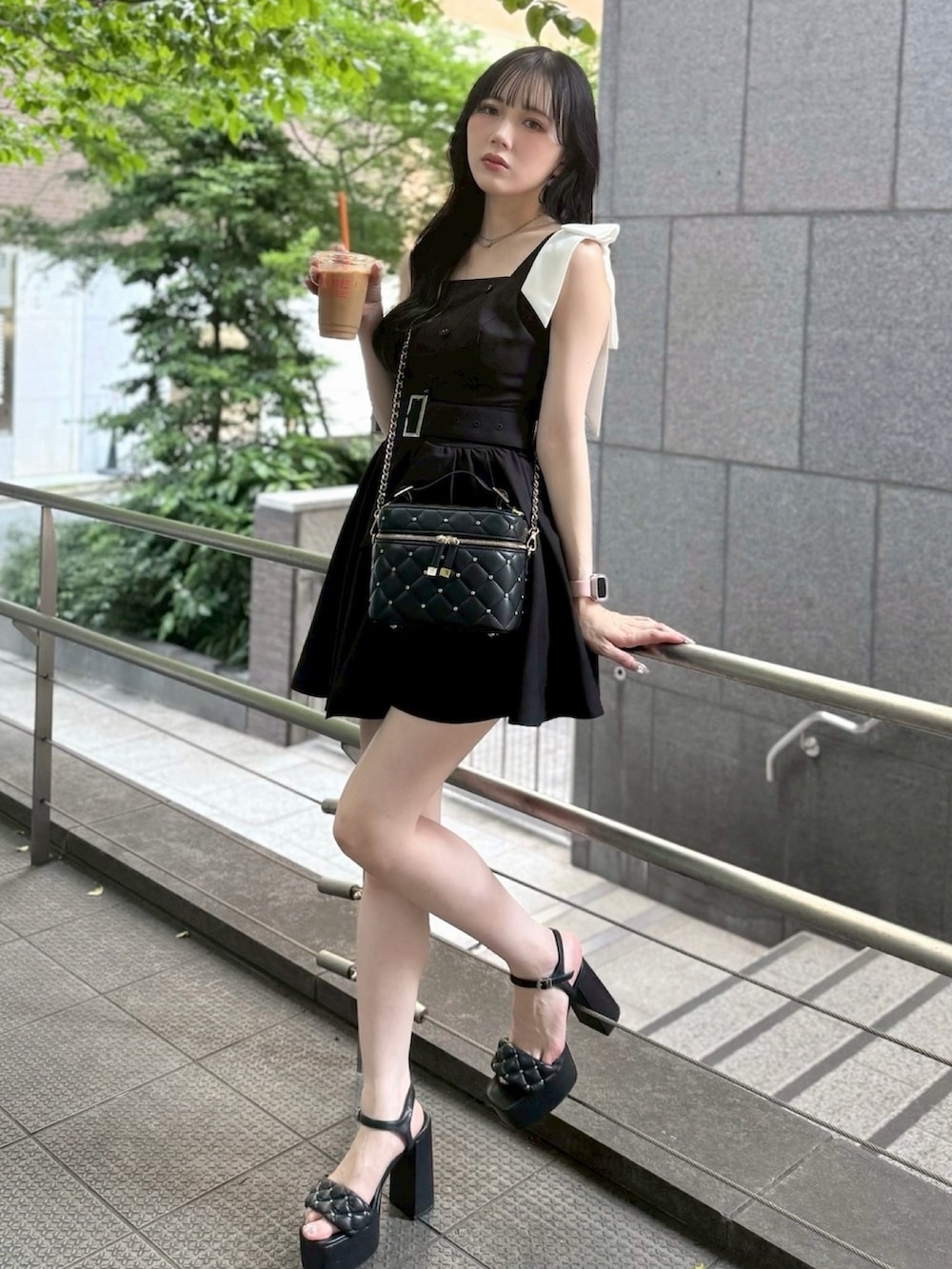 ブラック系のワンピース、ブラック系のショルダーバッグを着用したレディースの夏コーディネートの2枚目の写真