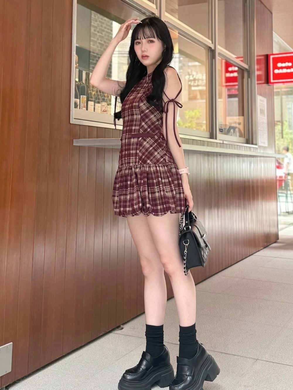 レッド系のワンピース、ブラック系のショルダーバッグ、ブラック系のローファーを着用したレディースの夏コーディネートの2枚目の写真