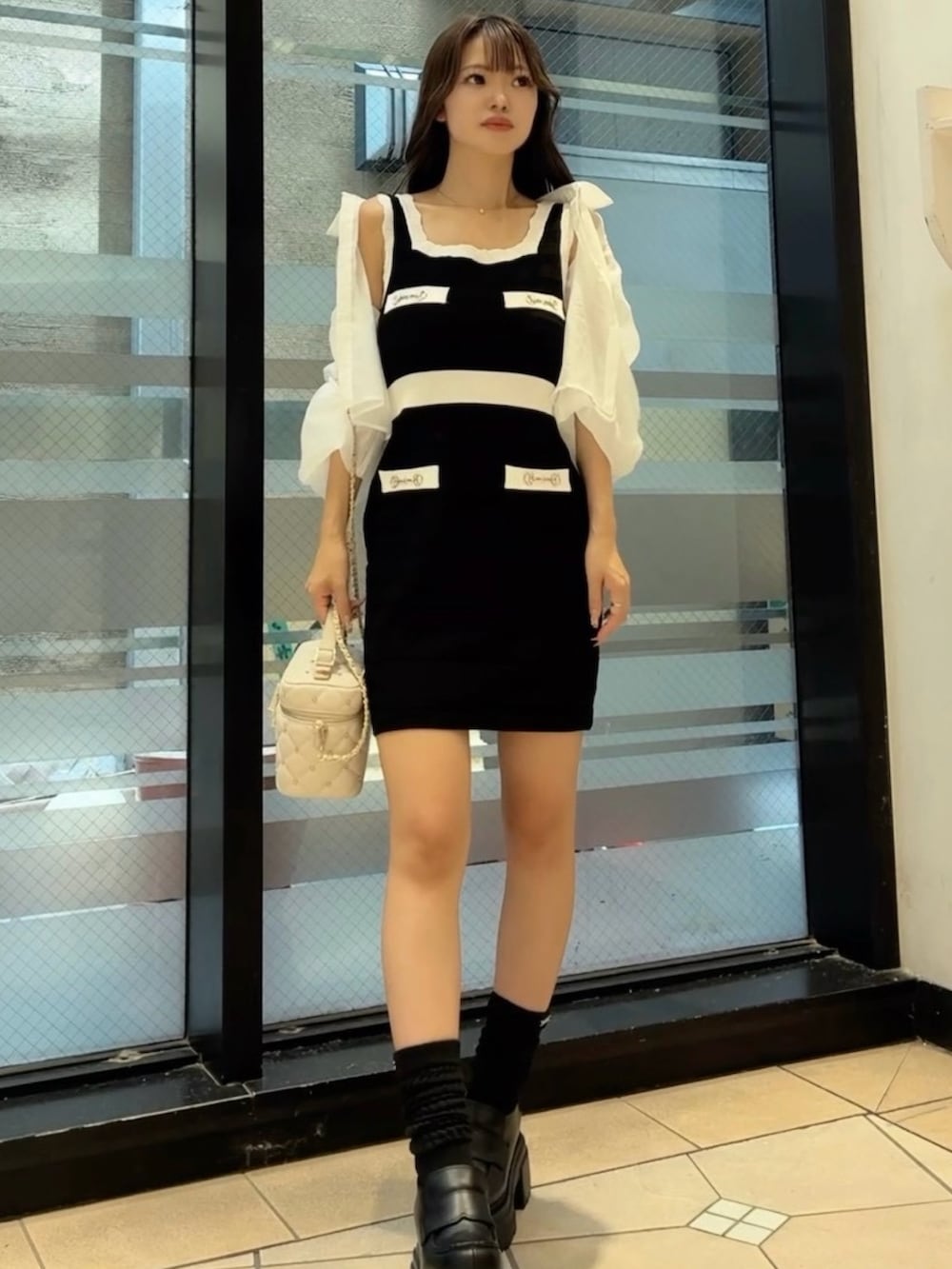 ブラック系のワンピース、ホワイト系のシャツ/ブラウスを着用したレディースの夏コーディネートの3枚目の写真