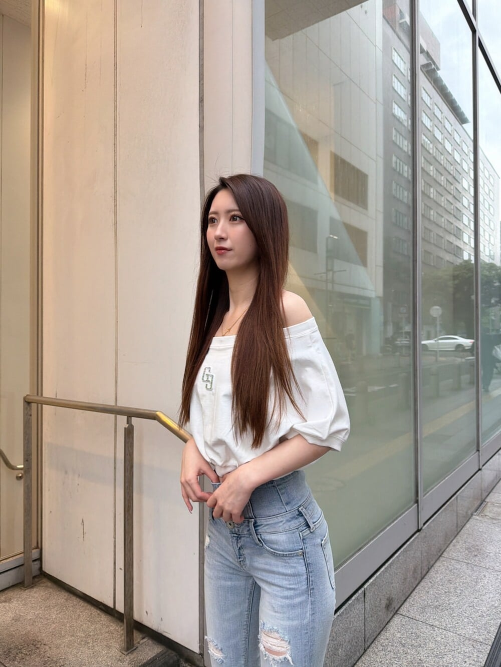ブルー系のデニムパンツ、ホワイト系のパンプス、ホワイト系のTシャツ/カットソーを着用したレディースの春コーディネートの5枚目の写真