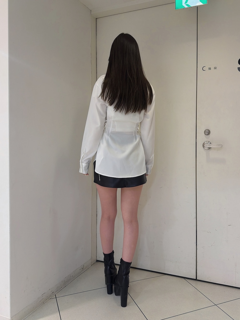 ホワイト系のシャツ/ブラウス、ブラック系のスカート、ブラック系のブーツを着用したレディースの秋コーディネートの3枚目の写真