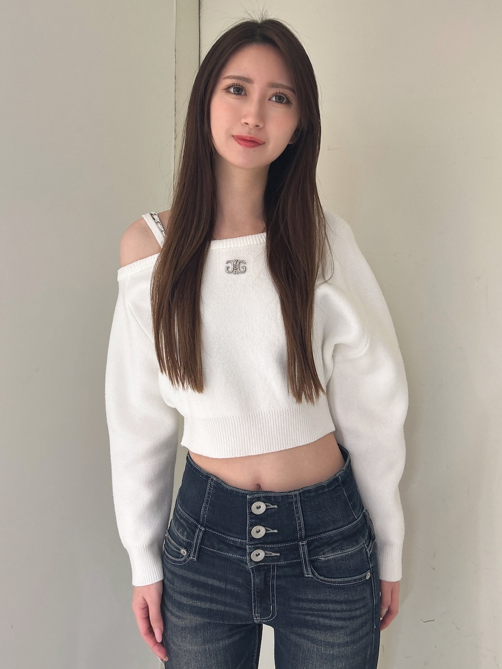 ホワイト系のニット/セーター、ブルー系のデニムパンツ、ブラック系のブーツを着用したレディースの冬コーディネートの4枚目の写真