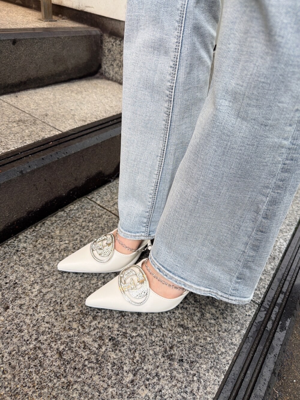 ブルー系のデニムパンツ、ホワイト系のパンプス、ホワイト系のTシャツ/カットソーを着用したレディースの春コーディネートの9枚目の写真