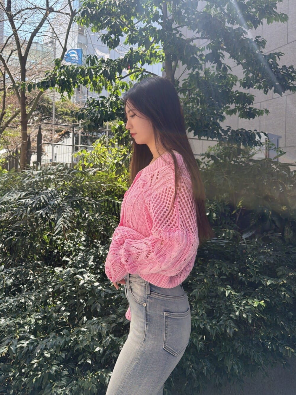 ブルー系のデニムパンツ、ホワイト系のサンダル、ピンク系のニット/セーターを着用したレディースの春コーディネートの5枚目の写真