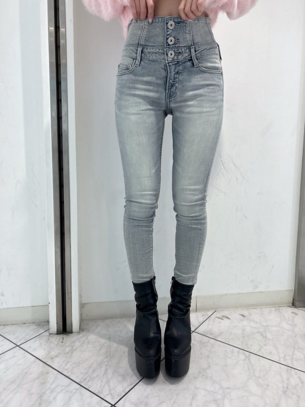 ブルー系のデニムパンツ、ピンク系のニット/セーター、ブラック系のブーツを着用したレディースの冬コーディネートの8枚目の写真