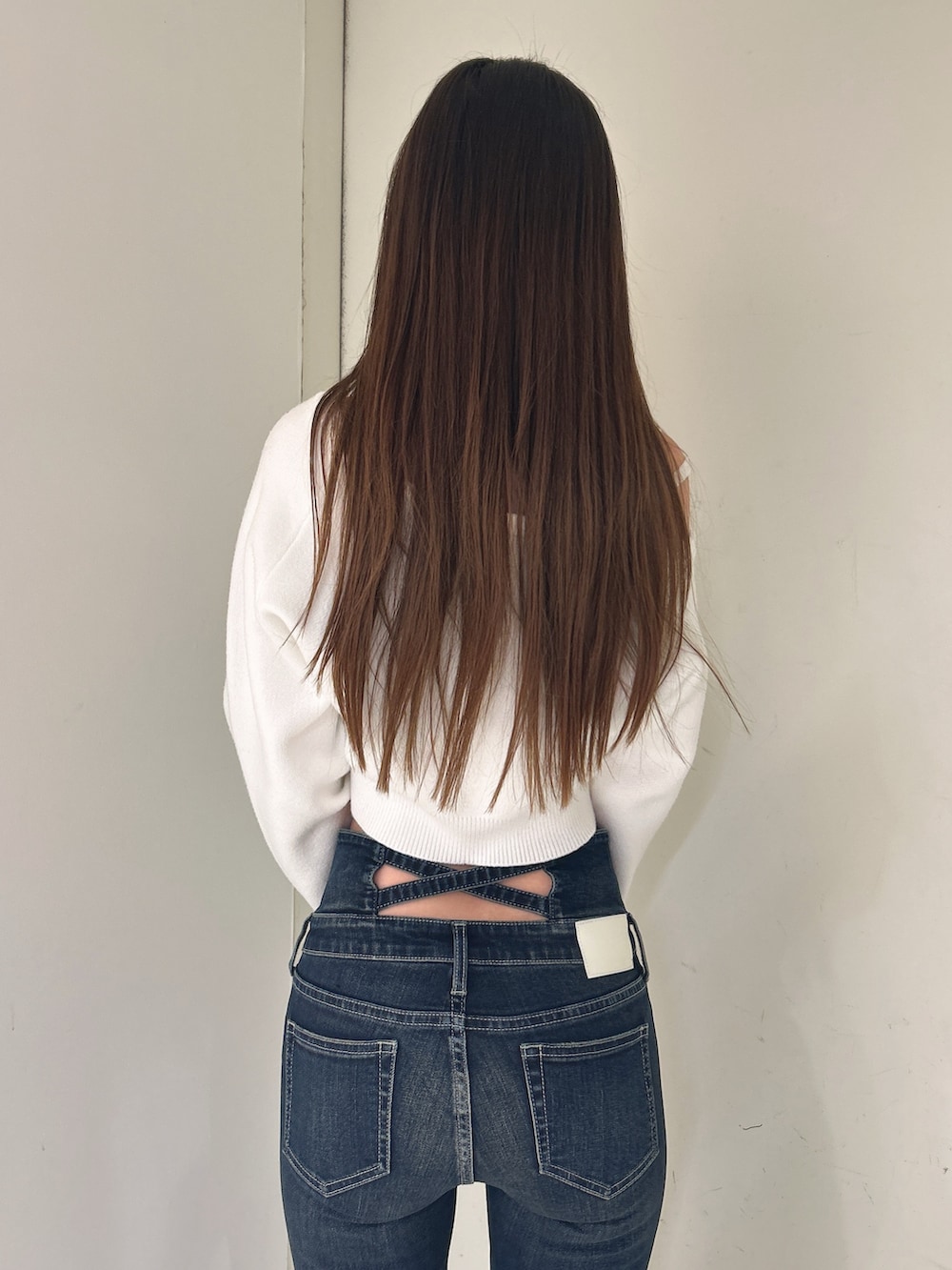 ホワイト系のニット/セーター、ブルー系のデニムパンツ、ブラック系のブーツを着用したレディースの冬コーディネートの6枚目の写真