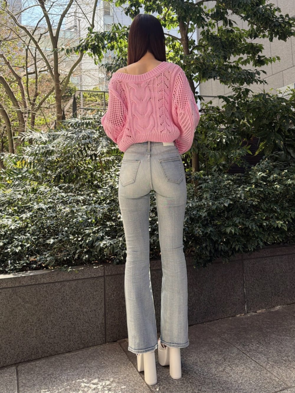 ブルー系のデニムパンツ、ホワイト系のサンダル、ピンク系のニット/セーターを着用したレディースの春コーディネートの3枚目の写真