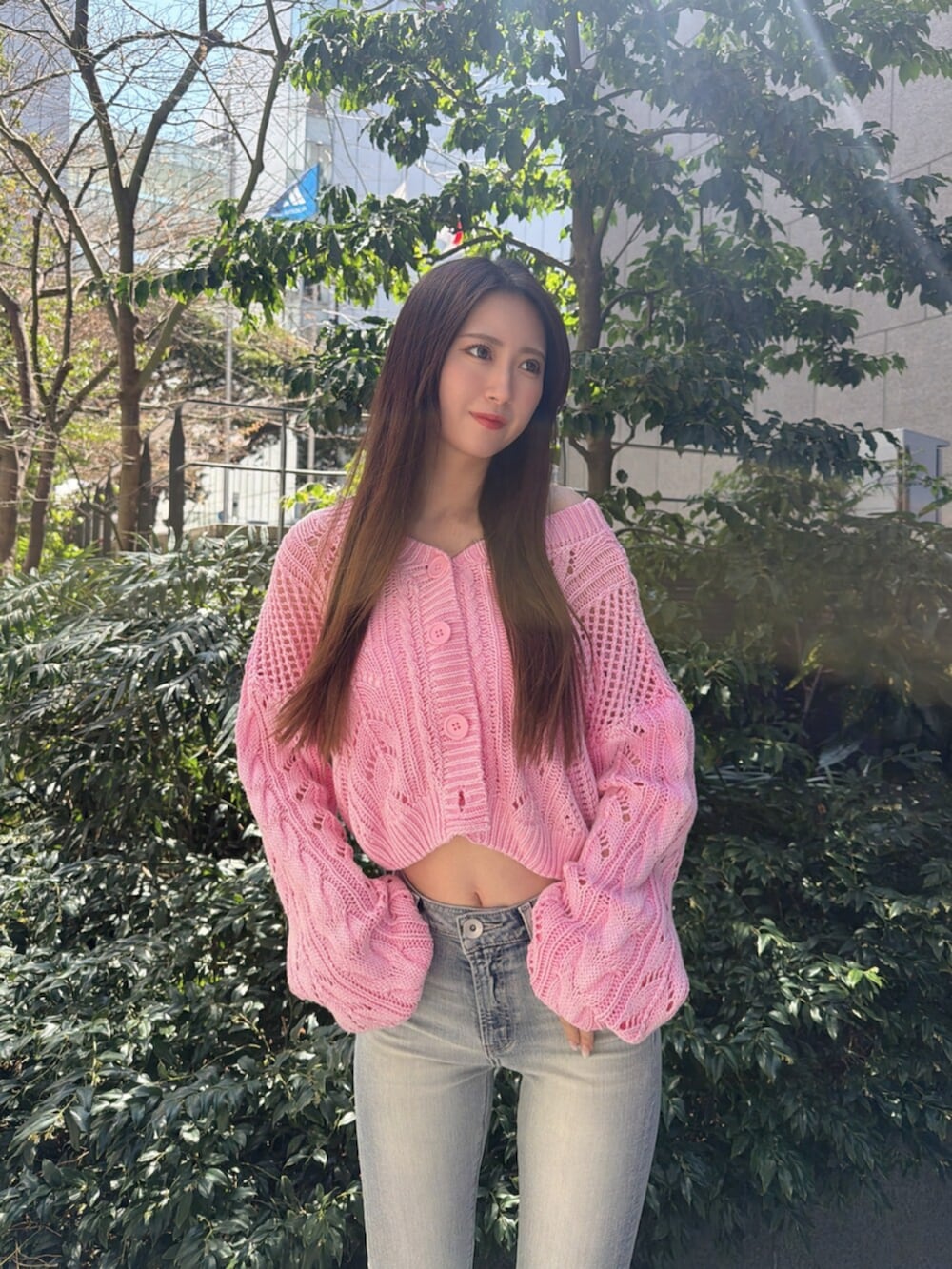 ブルー系のデニムパンツ、ホワイト系のサンダル、ピンク系のニット/セーターを着用したレディースの春コーディネートの4枚目の写真