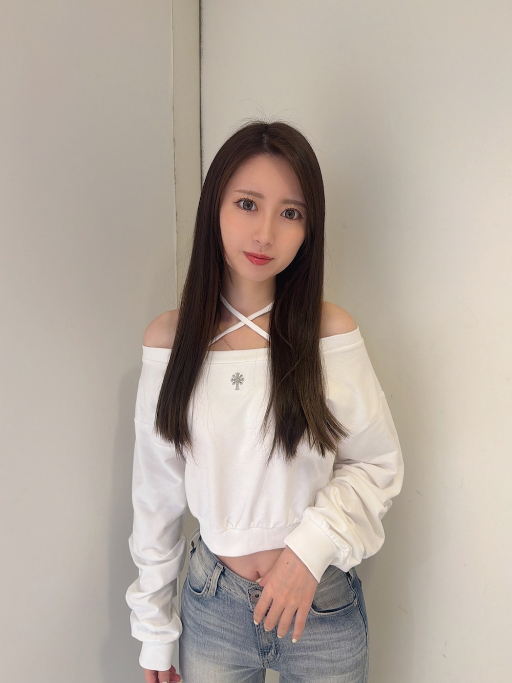 ホワイト系のスウェット、ブルー系のデニムパンツ、ホワイト系のブーツを着用したレディースの秋コーディネートの4枚目の写真