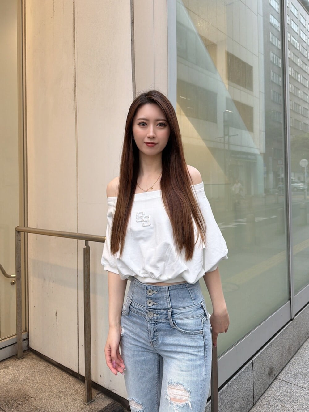 ブルー系のデニムパンツ、ホワイト系のパンプス、ホワイト系のTシャツ/カットソーを着用したレディースの春コーディネートの4枚目の写真