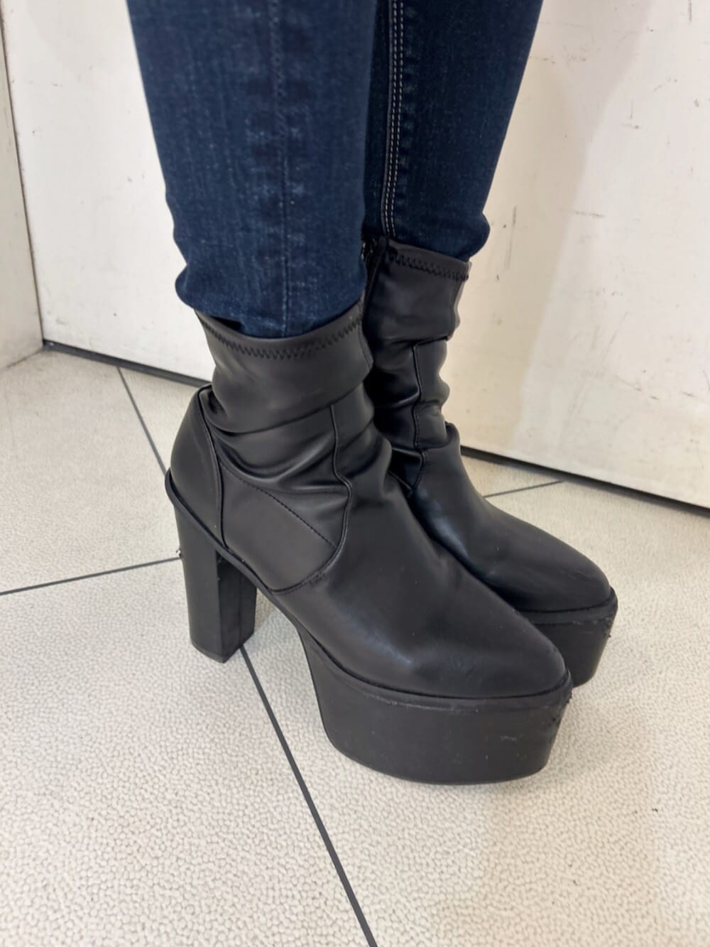 ブラック系のニット/セーター、ブラック系のバックパック/リュック、ブルー系のデニムパンツを着用したレディースの冬コーディネートの10枚目の写真