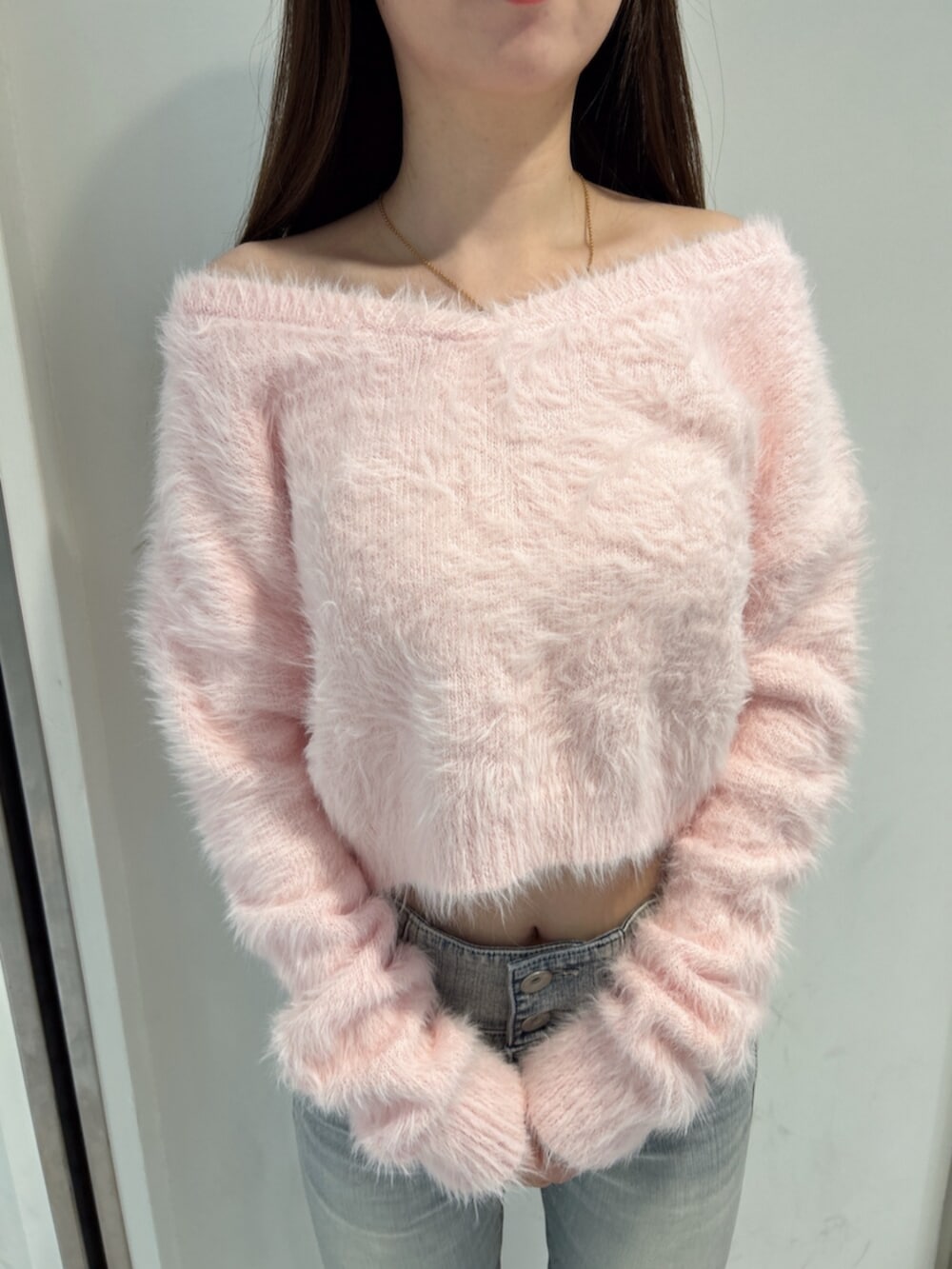 ブルー系のデニムパンツ、ピンク系のニット/セーター、ブラック系のブーツを着用したレディースの冬コーディネートの7枚目の写真