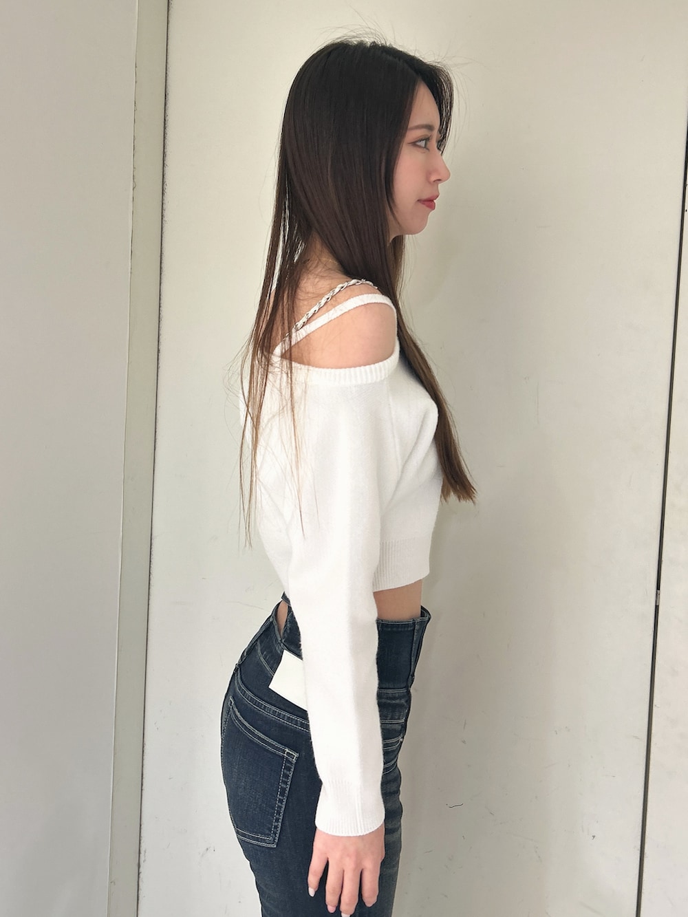 ホワイト系のニット/セーター、ブルー系のデニムパンツ、ブラック系のブーツを着用したレディースの冬コーディネートの5枚目の写真