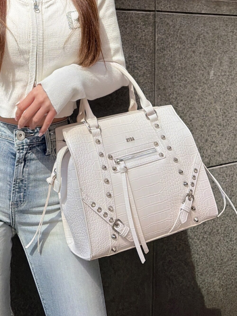 ブルー系のデニムパンツ、ホワイト系のサンダル、ホワイト系のハンドバッグを着用したレディースの春コーディネートの10枚目の写真