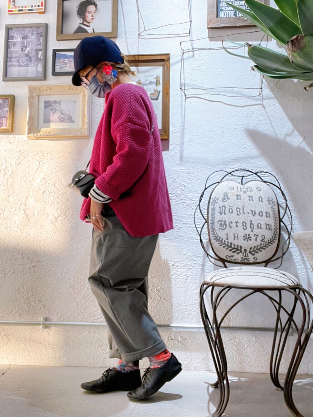 グレー系のパンツ、ブラック系のシューズ、ピンク系のカーディガン/ボレロを着用したレディースの秋コーディネートの2枚目の写真