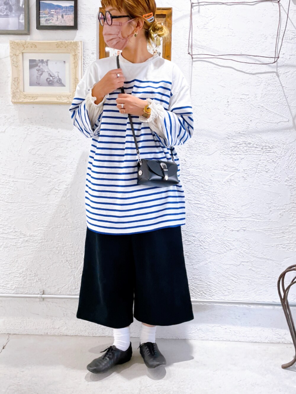 ブラック系のパンツ、ブラック系のシューズ、ホワイト系のトップスを着用したレディースの秋コーディネートの3枚目の写真