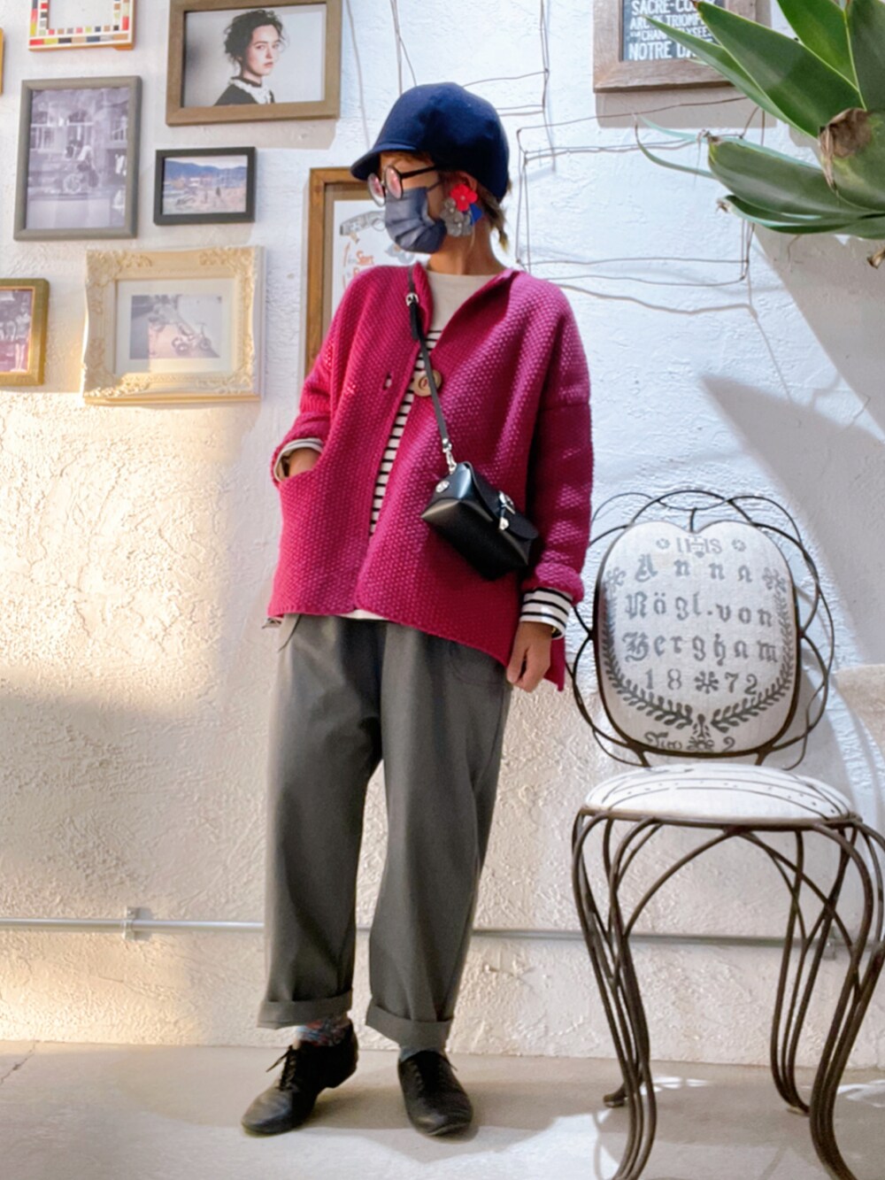 グレー系のパンツ、ブラック系のシューズ、ピンク系のカーディガン/ボレロを着用したレディースの秋コーディネートの3枚目の写真