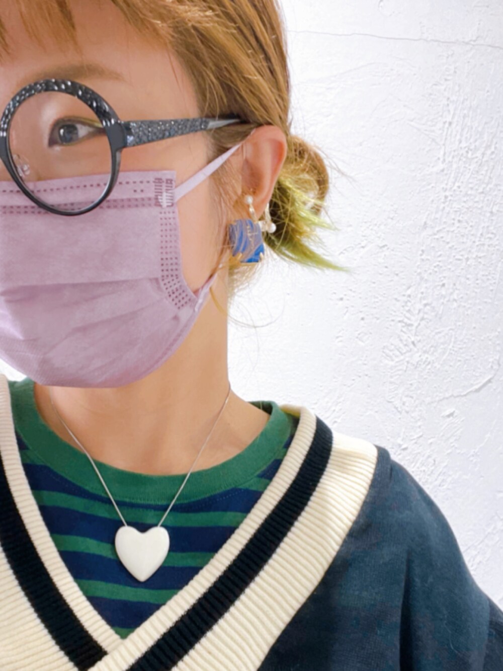 ホワイト系のパンツ、ピンク系のスニーカー、グリーン系のバッグを着用したレディースの秋コーディネートの3枚目の写真