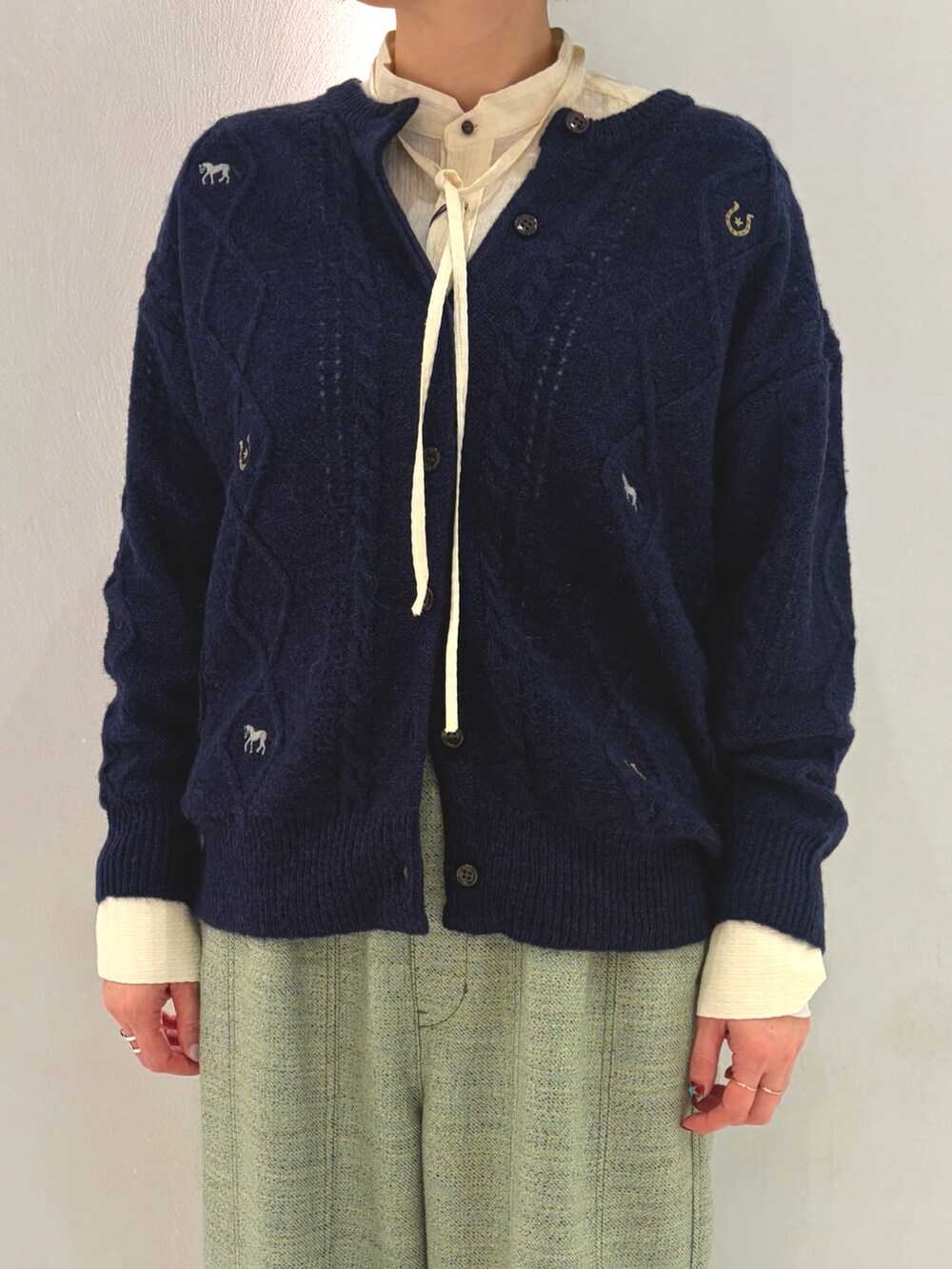 ホワイト系のシャツ/ブラウス、ブルー系のカーディガン/ボレロ、グリーン系のその他パンツを着用したレディースの秋コーディネートの2枚目の写真