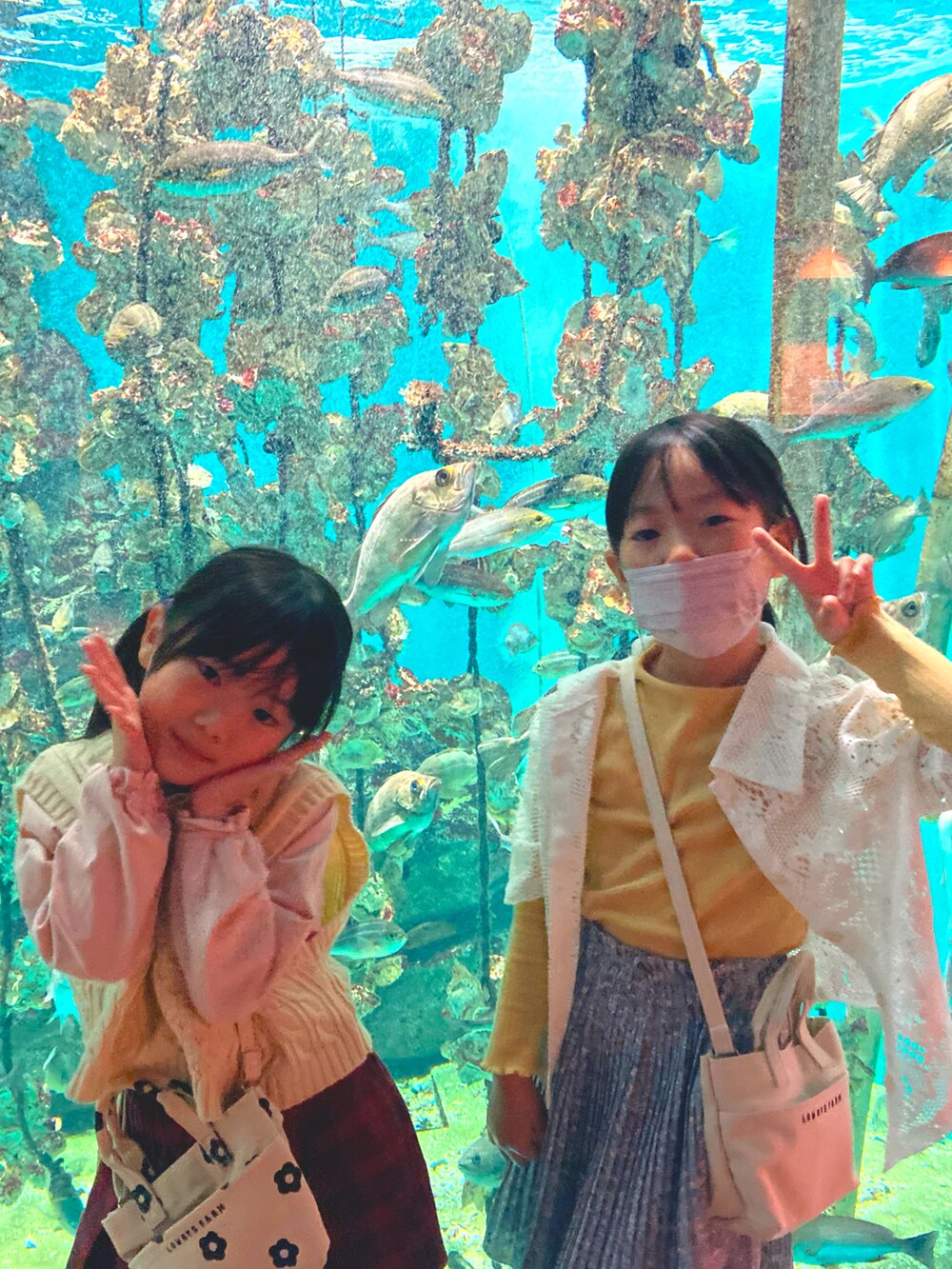 イエロー系のTシャツ/カットソー、パープル系のスカート、オレンジ系のワンピースを着用したキッズの春コーディネートの2枚目の写真