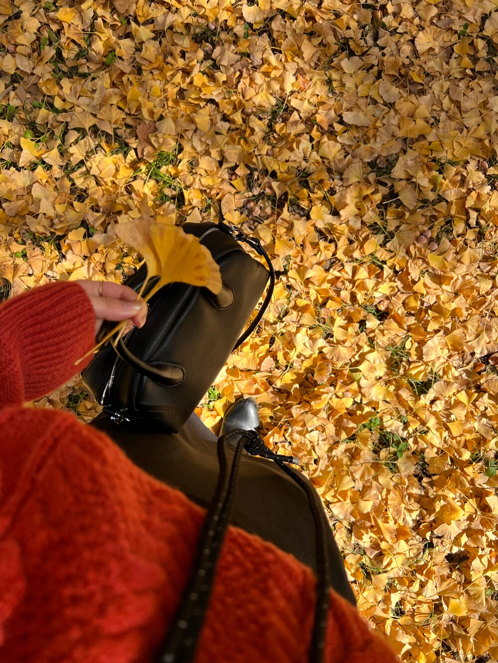 ブラック系のブーツ、オレンジ系のニット/セーターを着用したレディースの秋コーディネートの3枚目の写真