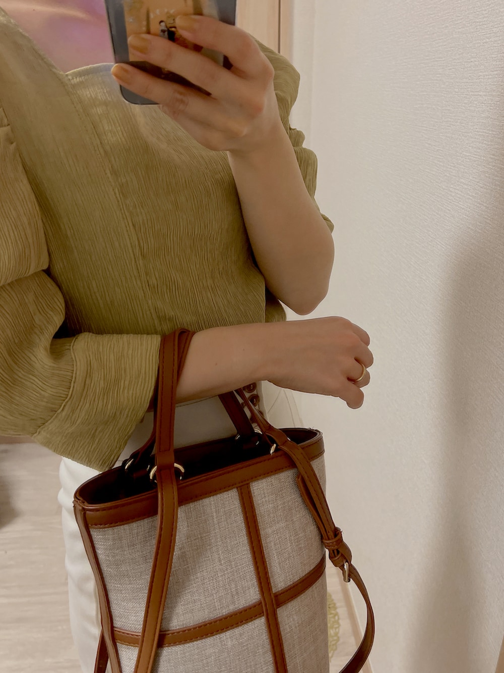 グリーン系のシャツ/ブラウス、ホワイト系のパンツ、ブラウン系のサンダルを着用したレディースの春コーディネートの2枚目の写真