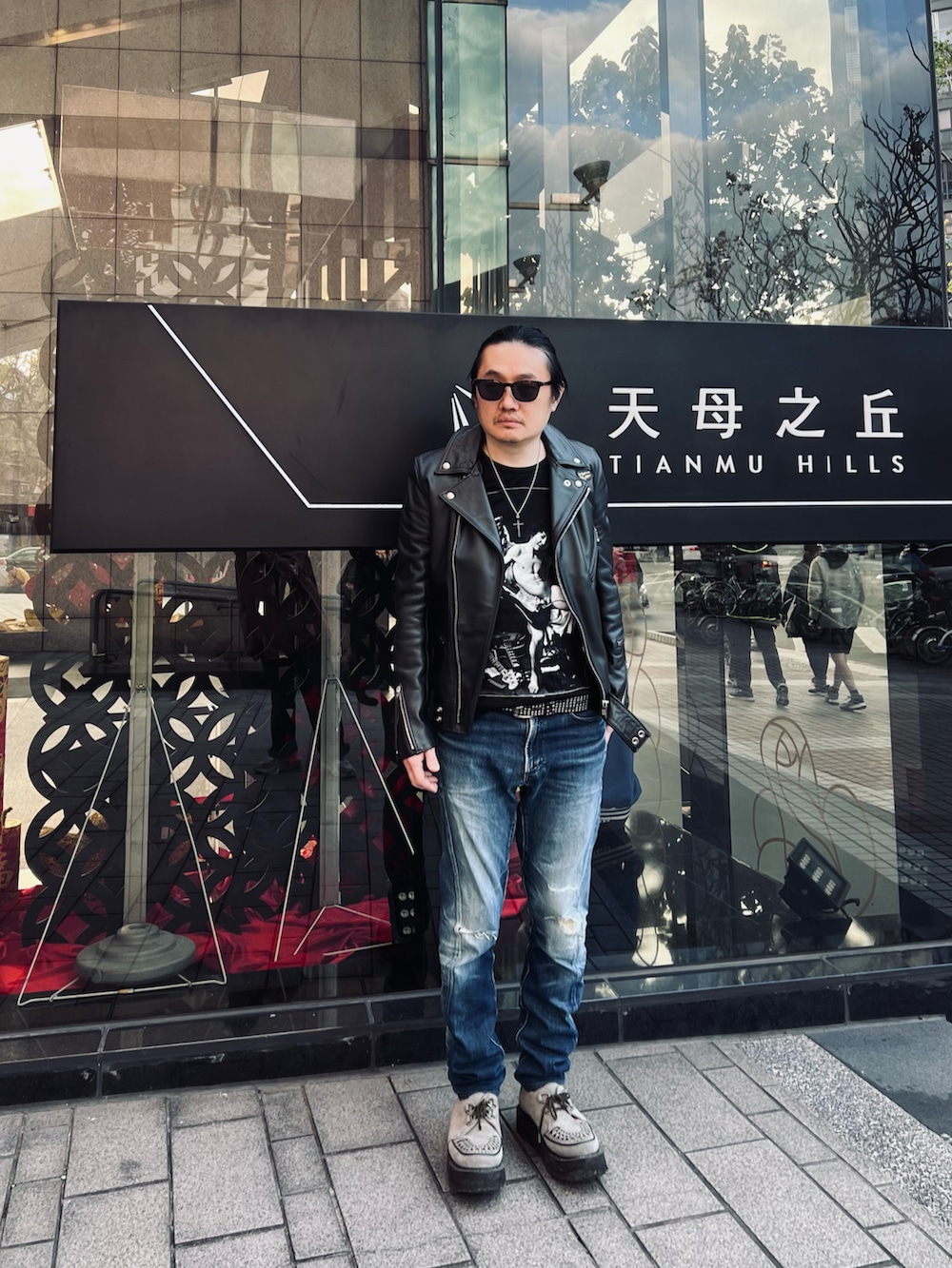 ブルー系のデニムパンツ、ブラック系のライダースジャケット、ブラック系のTシャツ/カットソーを着用したメンズの冬コーディネートの3枚目の写真