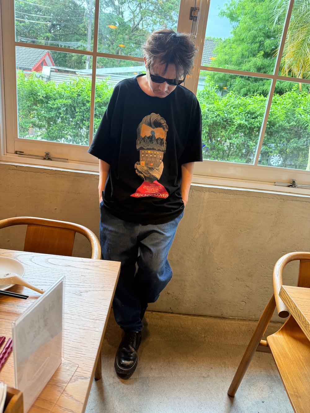 ブラック系のTシャツ/カットソー、ブルー系のデニムパンツ、ブラック系のローファーを着用したメンズの夏コーディネートの4枚目の写真