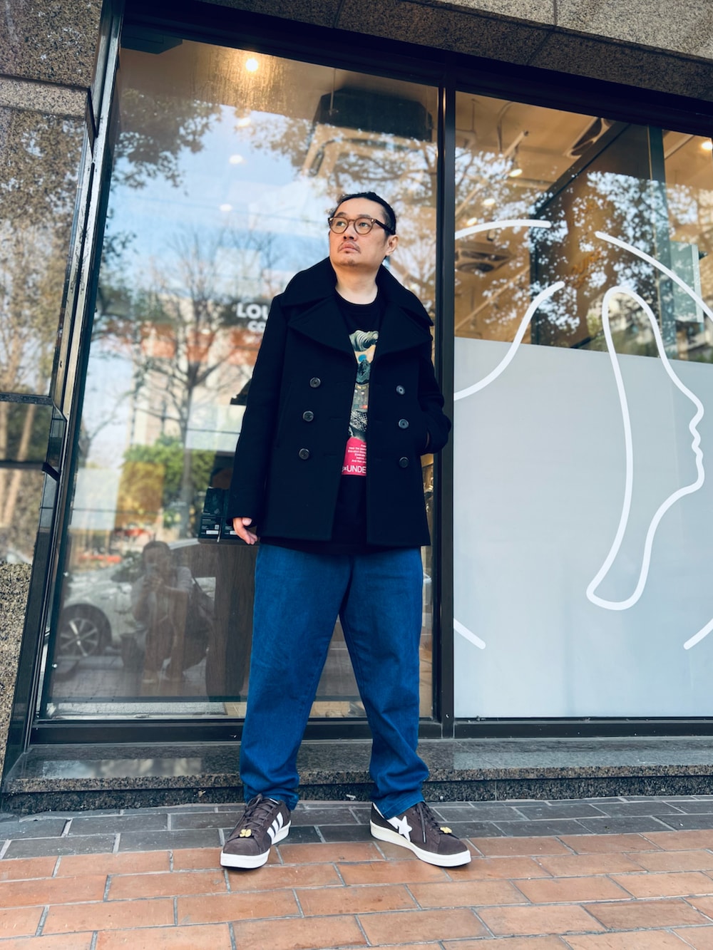 ブラック系のその他アウター、ブラック系のTシャツ/カットソー、ブルー系のデニムパンツを着用したメンズの春コーディネートの3枚目の写真