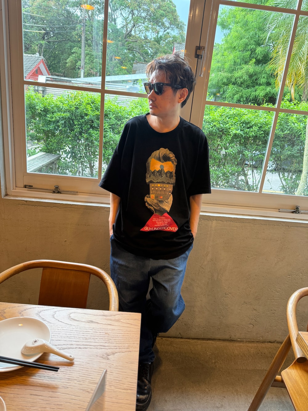 ブラック系のTシャツ/カットソー、ブルー系のデニムパンツ、ブラック系のローファーを着用したメンズの夏コーディネートの3枚目の写真