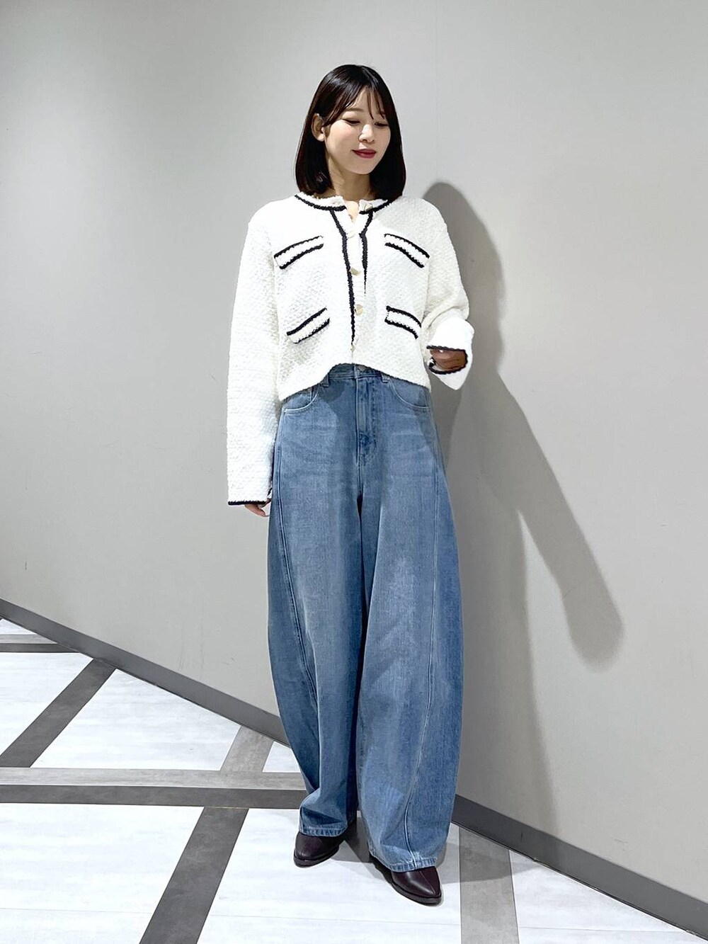 ブルー系のデニムパンツ、ホワイト系のカーディガン/ボレロを着用したレディースの冬コーディネートの2枚目の写真