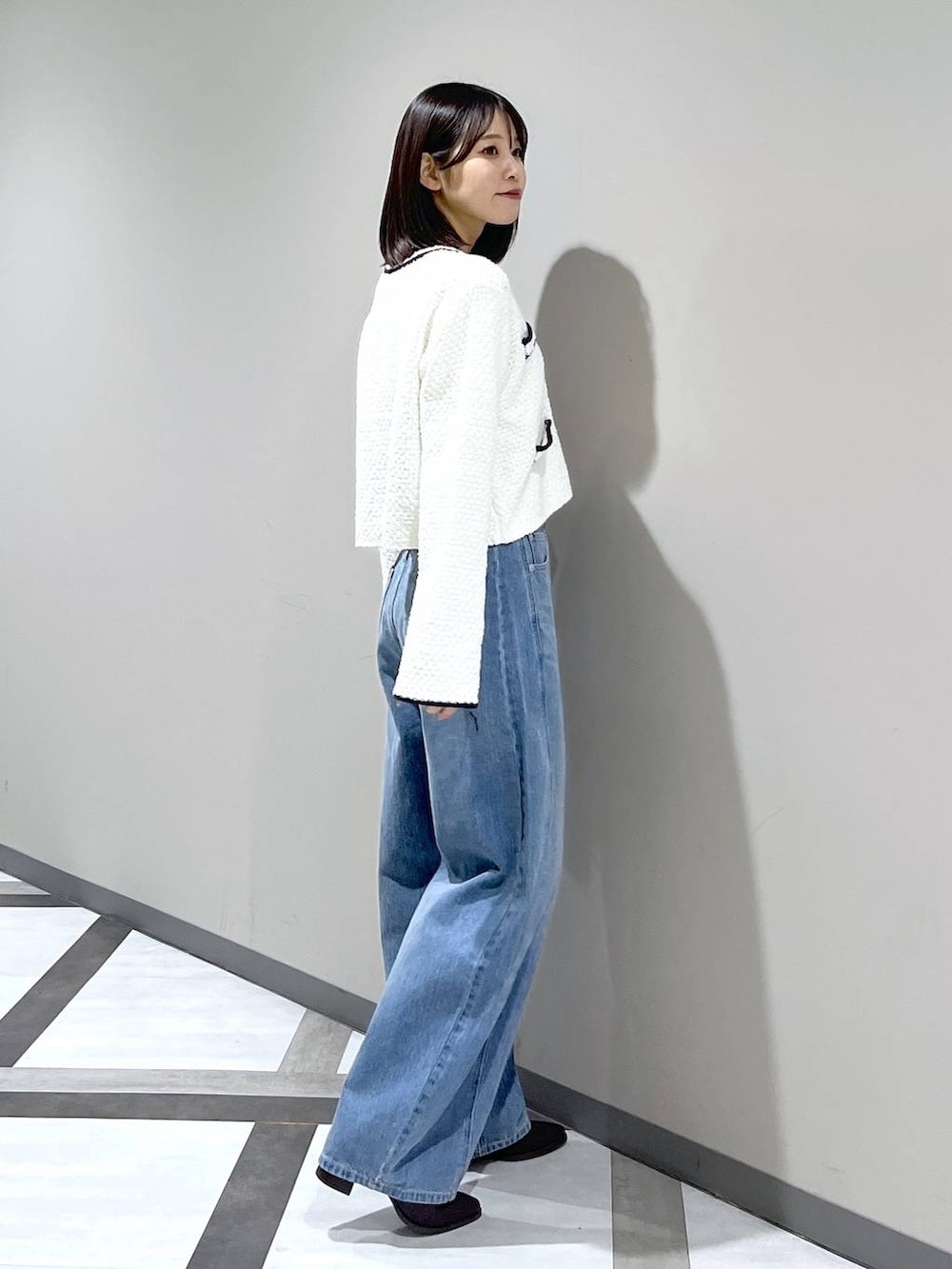 ブルー系のデニムパンツ、ホワイト系のカーディガン/ボレロを着用したレディースの冬コーディネートの3枚目の写真