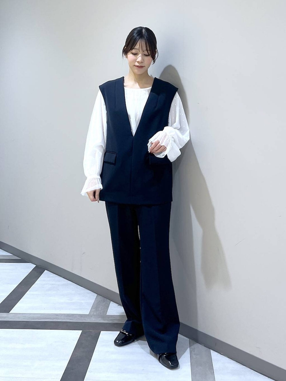 ブラック系のローファー、ブラック系のスーツセット、ホワイト系のシャツ/ブラウスを着用したレディースの冬コーディネートの2枚目の写真