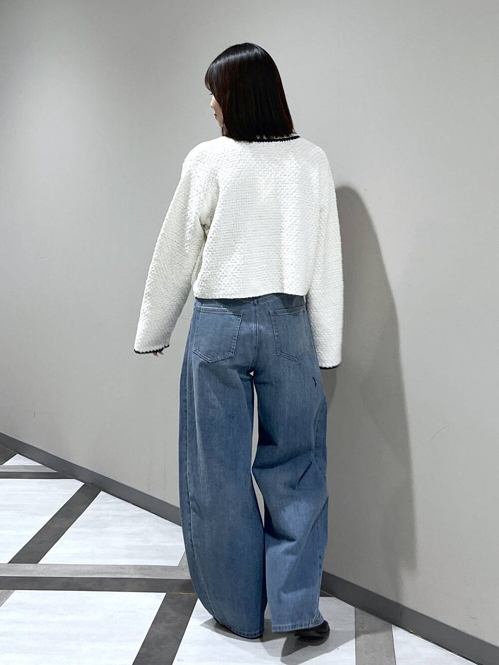 ブルー系のデニムパンツ、ホワイト系のカーディガン/ボレロを着用したレディースの冬コーディネートの4枚目の写真