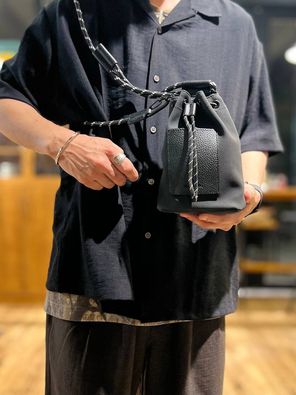 ブラウン系のその他パンツ、ブラック系のショルダーバッグ、ブラック系のサンダルを着用したメンズの夏コーディネートの8枚目の写真