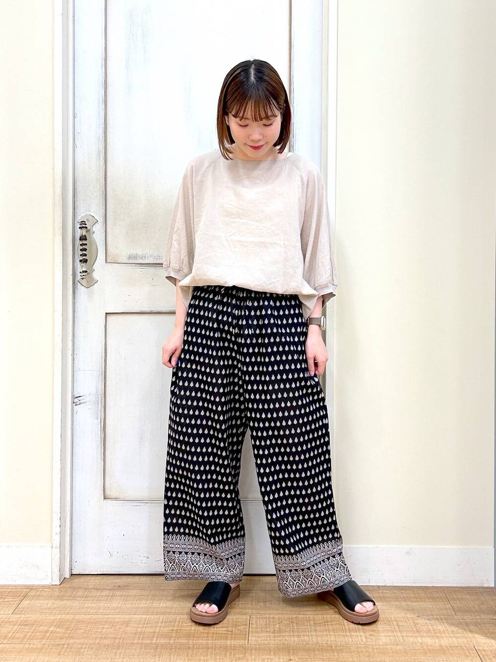 ブラウン系のショルダーバッグ、ブラック系のその他パンツ、ホワイト系のタンクトップを着用したレディースの春コーディネートの6枚目の写真