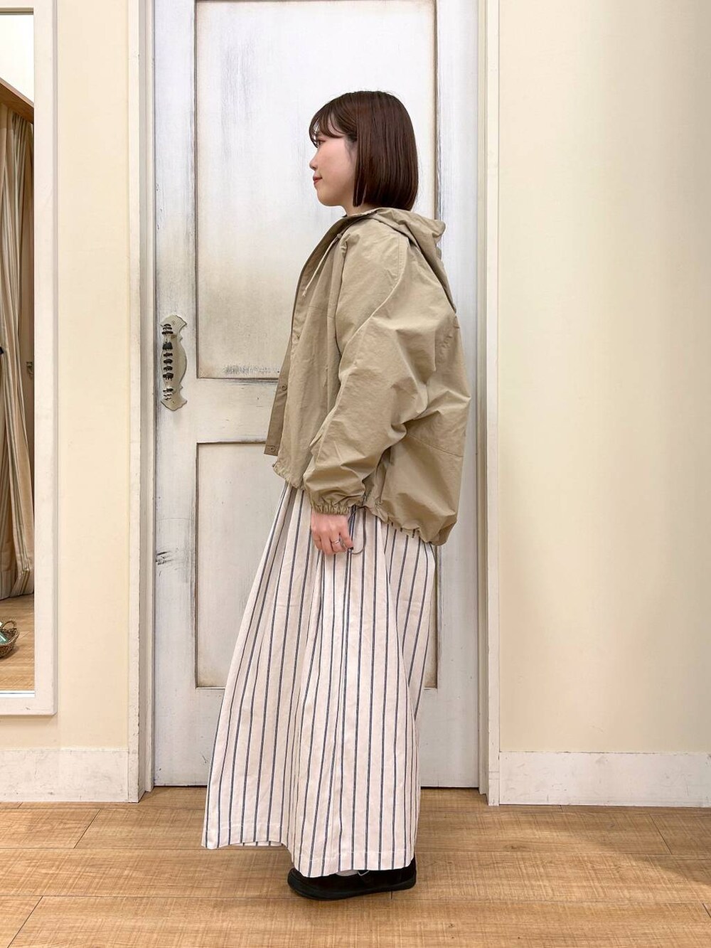 ブラウン系のTシャツ/カットソー、ブラウン系のスニーカー、ベージュ系のマウンテンパーカーを着用したレディースの春コーディネートの4枚目の写真