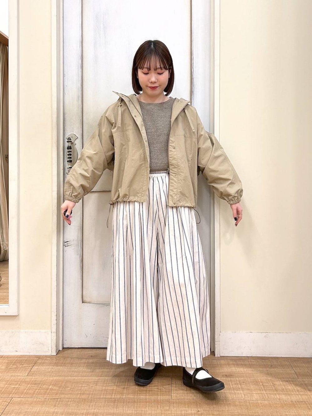 ブラウン系のTシャツ/カットソー、ブラウン系のスニーカー、ベージュ系のマウンテンパーカーを着用したレディースの春コーディネートの3枚目の写真