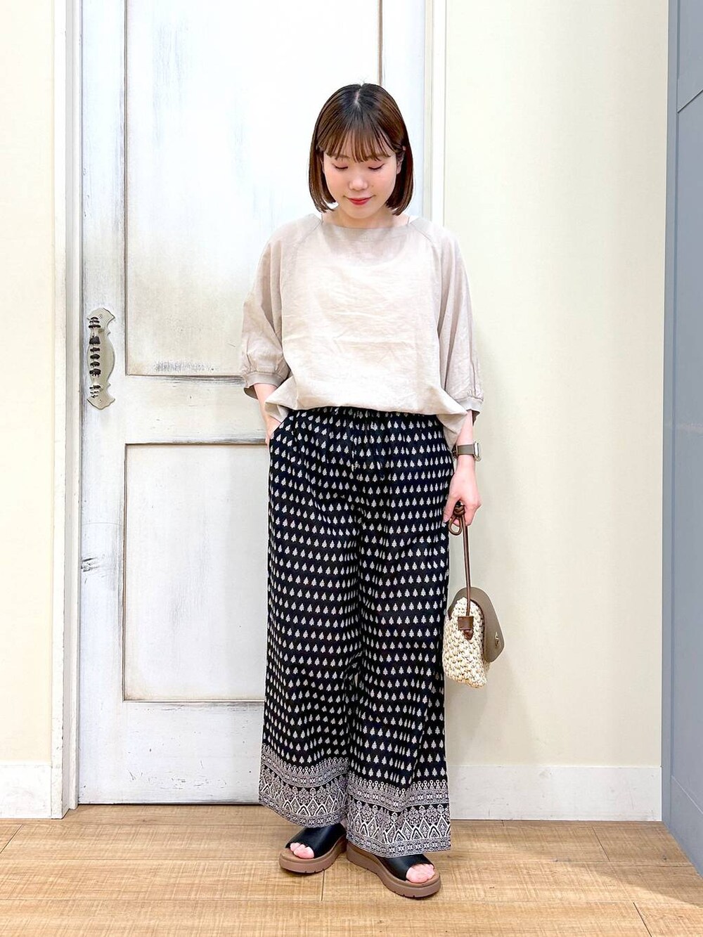 ブラウン系のショルダーバッグ、ブラック系のその他パンツ、ホワイト系のタンクトップを着用したレディースの春コーディネートの7枚目の写真